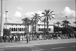 Image du Maroc Professionnelle de  Tout un peuple hommes, femmes, enfants de tous âges était là, assis sur le muret qui clôture le jardin situé juste en face de la wilaya de Casablanca. Ce beau monde attend passionnément le départ de la fontaine lumineuse, Vendredi 10 Août 1984. A l’époque au début du siècle dernier (20e) on a planté des palmiers ainsi que d’autres végétaux pour réduire l’angoisse de tous ceux qui ont une affaire au Palais de Justice. (Photo / Abdeljalil Bounhar) 